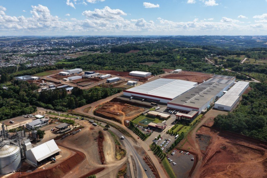 Vista aérea do Distrito Industrial, com galpões de indústrias e a cidade de Erechim
